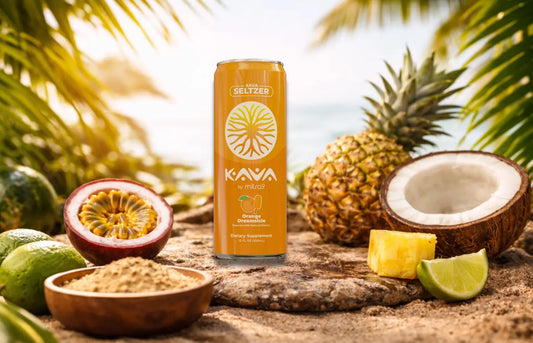 Orange Dreamsicle Kava seltzer by Mitra9 displayed on a tropical beach setting with pineapple, coconut, lime, and passion fruit, showcasing a non-alcoholic functional seltzer designed for balance and relaxation