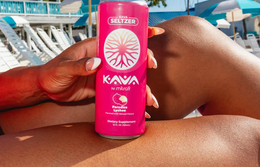 Mitra9 Paradise Lychee kava seltzer can held poolside on a sunny day, showcasing a refreshing functional kava drink for relaxed summer moments.